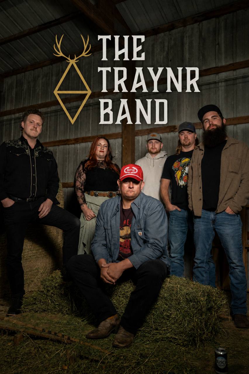 The six members of The Traynr Band posed together in a barn